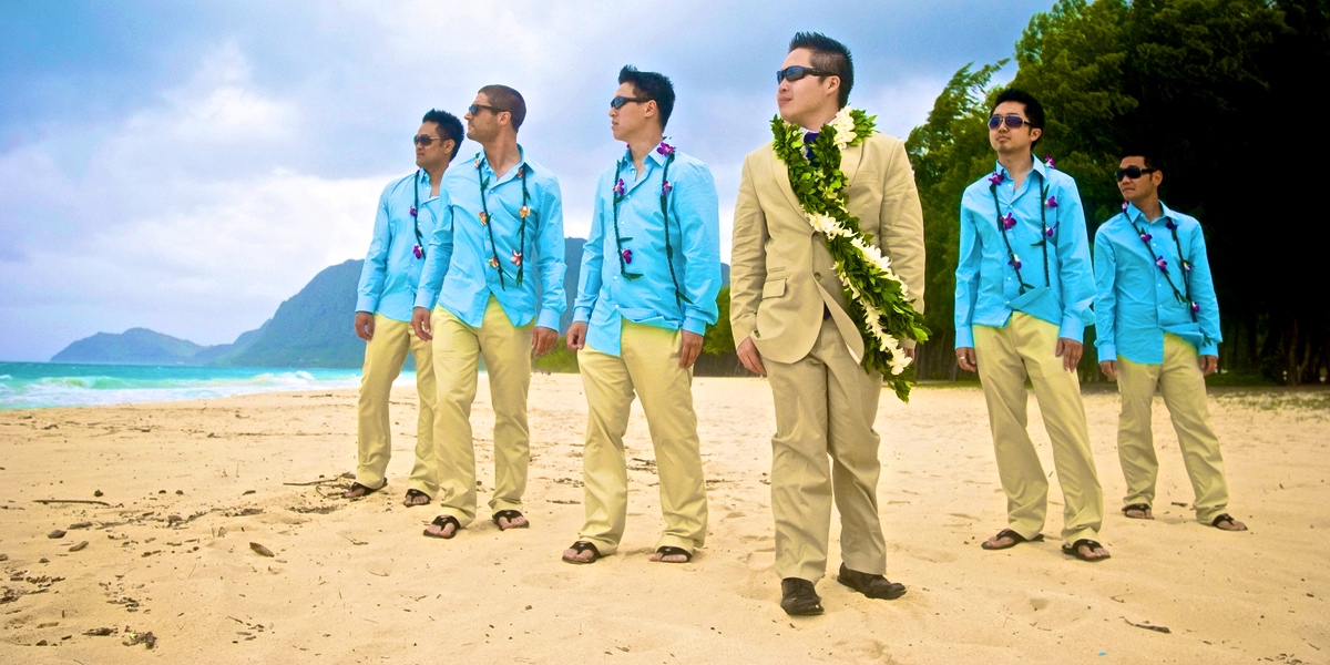 groom wearing maile lei with white orchids with groomsmen